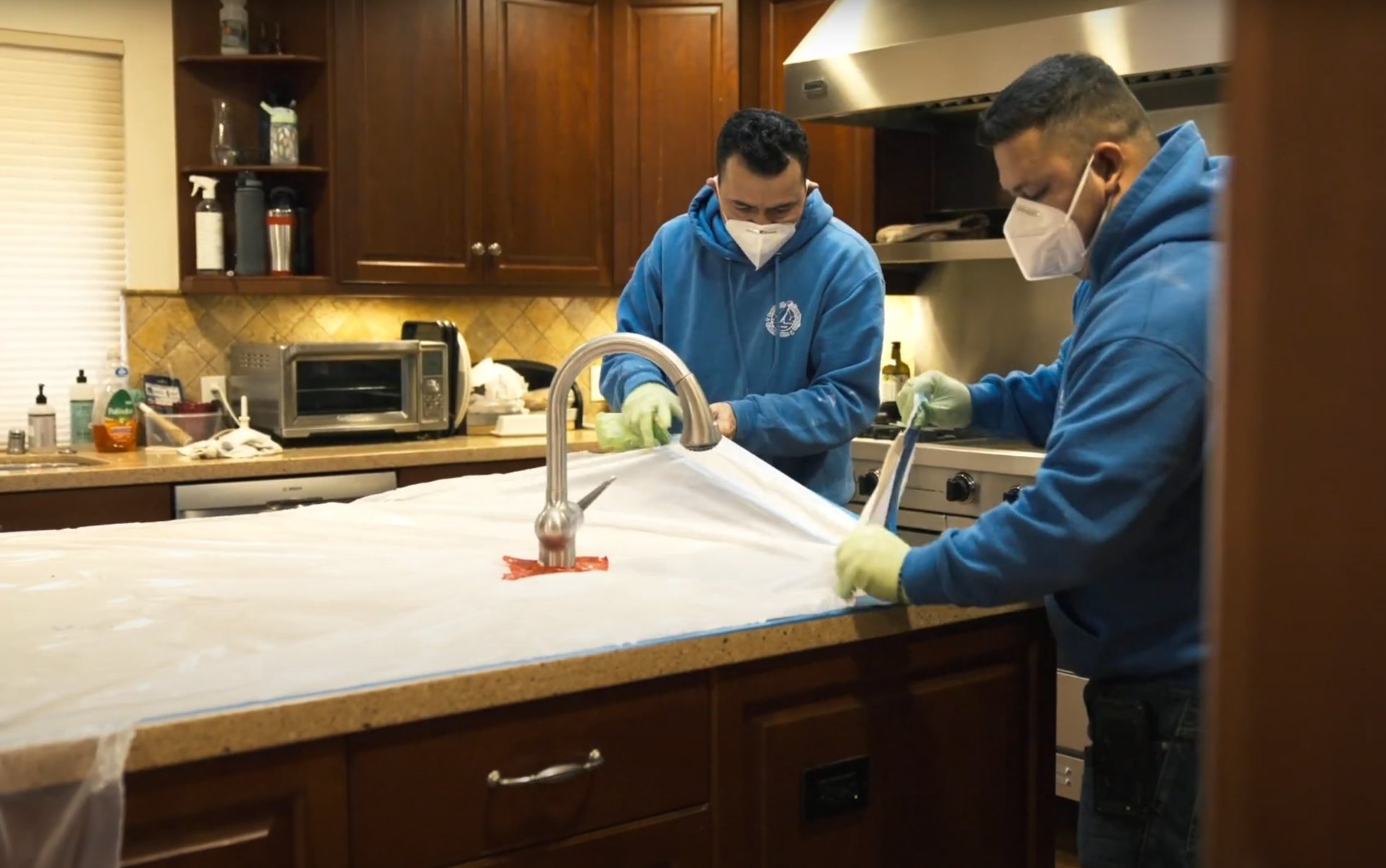 Professional water damage restoration services Water damage restoration team working in kitchen with professional equipment and protective gear