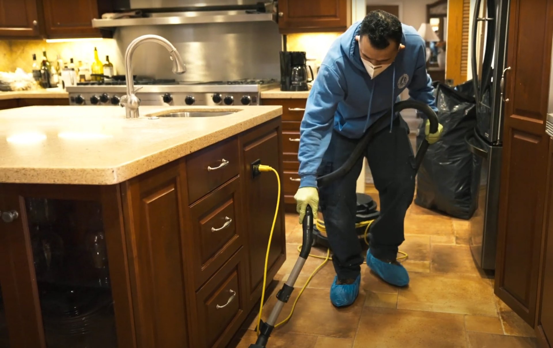 Professional cleaning and sanitization after water damage Water damage restoration specialist cleaning and sanitizing kitchen surfaces with professional equipment